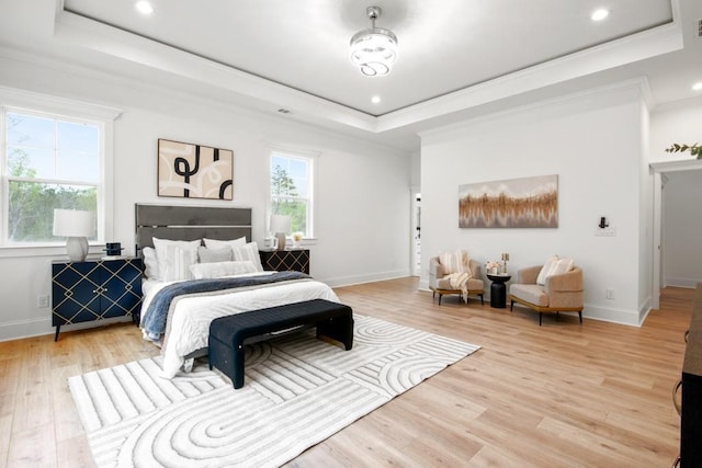 bedroom with a tray ceiling, baseboards, crown molding, and wood finished floors
