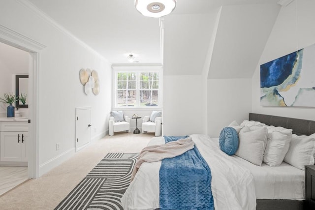 bedroom with crown molding, lofted ceiling, carpet, baseboards, and connected bathroom