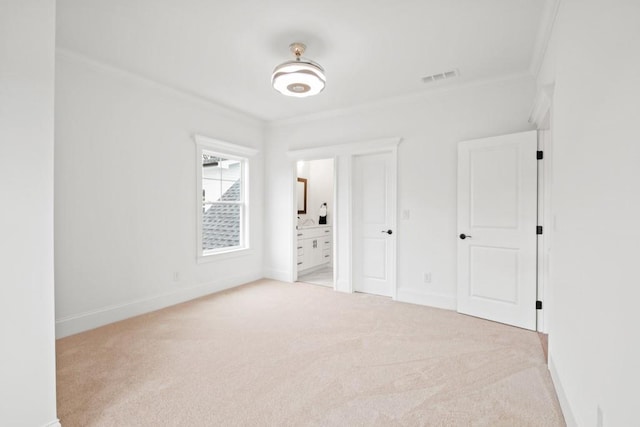 unfurnished bedroom featuring carpet floors, ornamental molding, baseboards, and visible vents