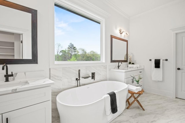 full bathroom with a sink, two vanities, a soaking tub, marble finish floor, and ornamental molding