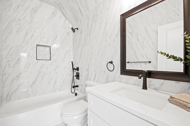 bathroom featuring tile walls, toilet, vanity, and washtub / shower combination