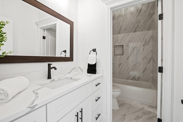 full bathroom with marble finish floor, washtub / shower combination, toilet, and vanity