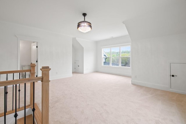 empty room featuring light carpet and baseboards