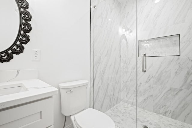 bathroom featuring toilet, vanity, and a marble finish shower