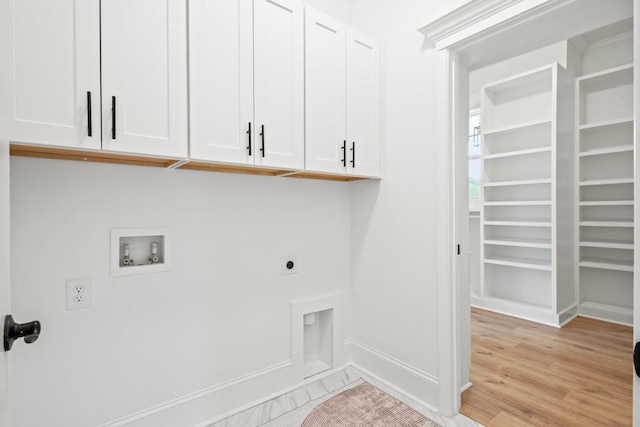 clothes washing area featuring hookup for an electric dryer, baseboards, light wood-style floors, cabinet space, and washer hookup
