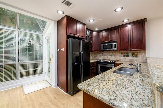 7500 Roswell Rd Unit 18, Sandy Springs, GA 30350 - kitchen with stainless steel appliances, a sink, light stone countertops, light wood finished floors, and backsplash