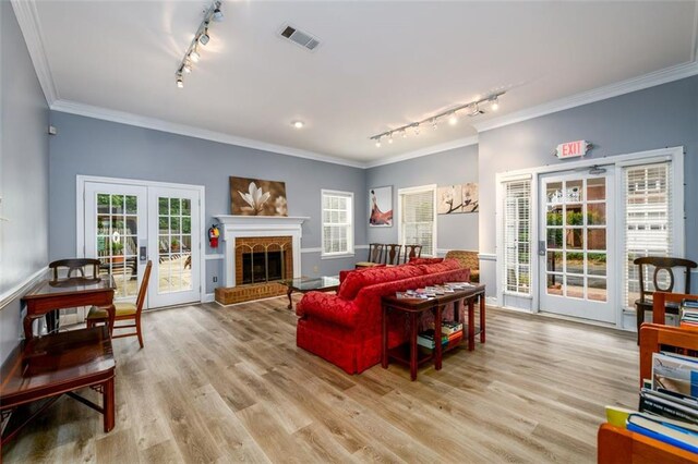 7500 Roswell Rd Unit 18, Sandy Springs, GA 30350 - living room featuring rail lighting, french doors, ornamental molding, light wood-style flooring, and healthy amount of natural light