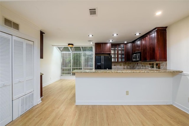 7500 Roswell Rd Unit 18, Sandy Springs, GA 30350 - kitchen with black fridge with ice dispenser, stainless steel microwave, a peninsula, light wood-style floors, and recessed lighting