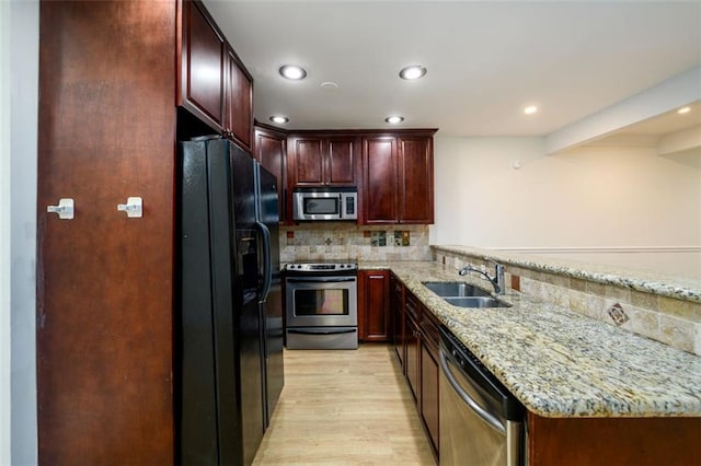 7500 Roswell Rd Unit 18, Sandy Springs, GA 30350 - kitchen with appliances with stainless steel finishes, a sink, light wood-style floors, decorative backsplash, and a peninsula