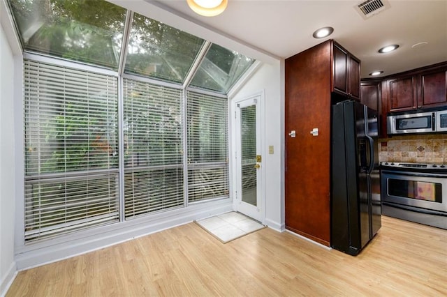 7500 Roswell Rd Unit 18, Sandy Springs, GA 30350 - kitchen featuring appliances with stainless steel finishes, light wood-type flooring, baseboards, backsplash, and dark brown cabinets