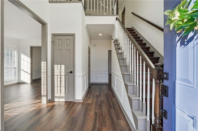 foyer with dark hardwood / wood-style floors and crown molding