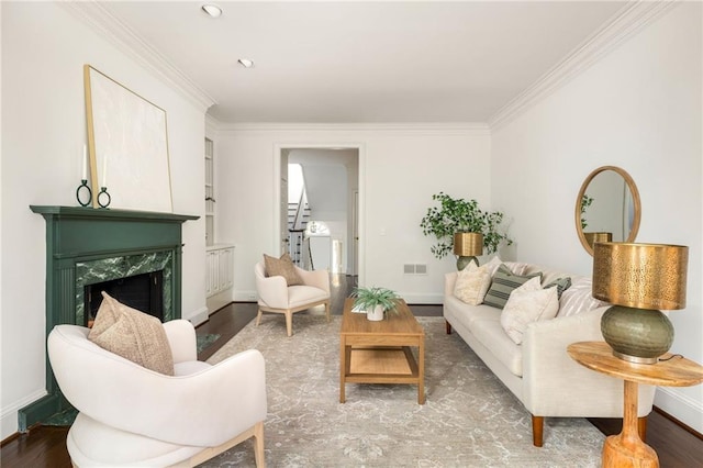 living room with hardwood / wood-style floors, crown molding, a premium fireplace, and built in shelves