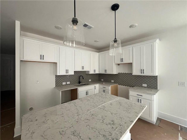 1714 Gunnin Trce NW, Atlanta, GA 30318 - kitchen with a sink, baseboards, backsplash, white cabinets, and hanging light fixtures
