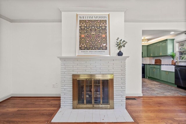 1286 Calhoun Ter SW, Atlanta, GA 30314 - interior details featuring wood finished floors, a brick fireplace, black dishwasher, baseboards, and ornamental molding