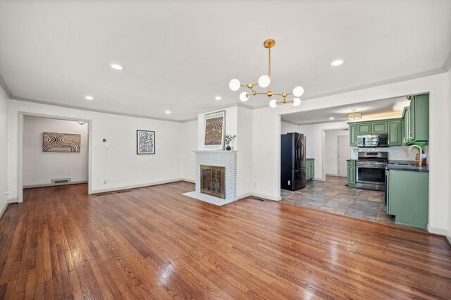 1286 Calhoun Ter SW, Atlanta, GA 30314 - unfurnished living room with a sink, hardwood / wood-style flooring, visible vents, and crown molding