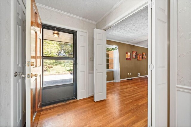 doorway featuring crown molding, hardwood / wood-style floors, and a textured ceiling