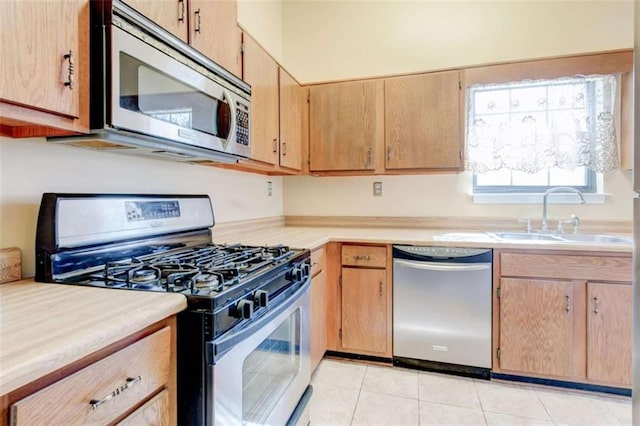 2211 Jonathan Ave, Lithonia, GA 30058 - kitchen with stainless steel appliances, a sink, light countertops, and light tile patterned floors