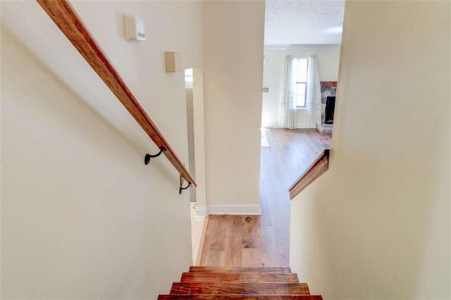 2211 Jonathan Ave, Lithonia, GA 30058 - staircase featuring wood finished floors, baseboards, and a fireplace with raised hearth