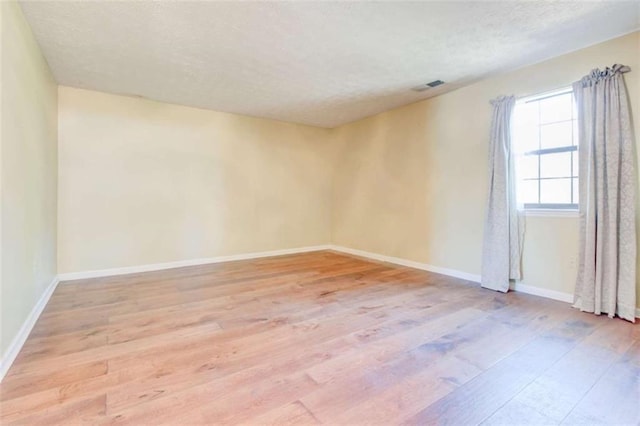 2211 Jonathan Ave, Lithonia, GA 30058 - empty room with light wood finished floors, baseboards, and a textured ceiling