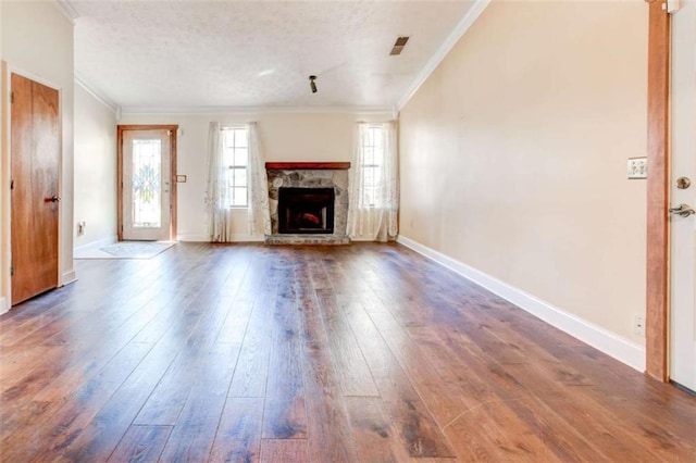 2211 Jonathan Ave, Lithonia, GA 30058 - unfurnished living room with ornamental molding, wood-type flooring, a stone fireplace, baseboards, and a textured ceiling