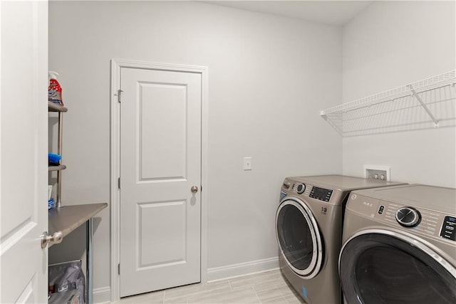 laundry area featuring washer and clothes dryer and baseboards