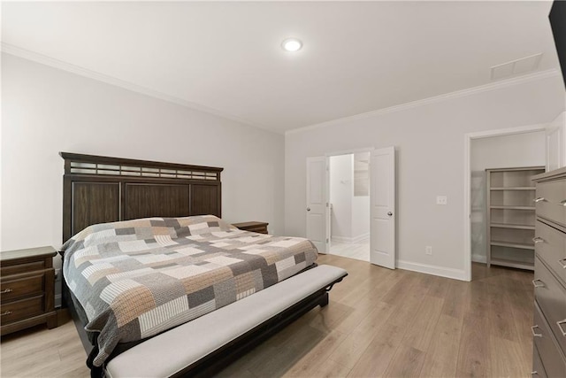 bedroom featuring crown molding, light wood-style floors, baseboards, a spacious closet, and recessed lighting