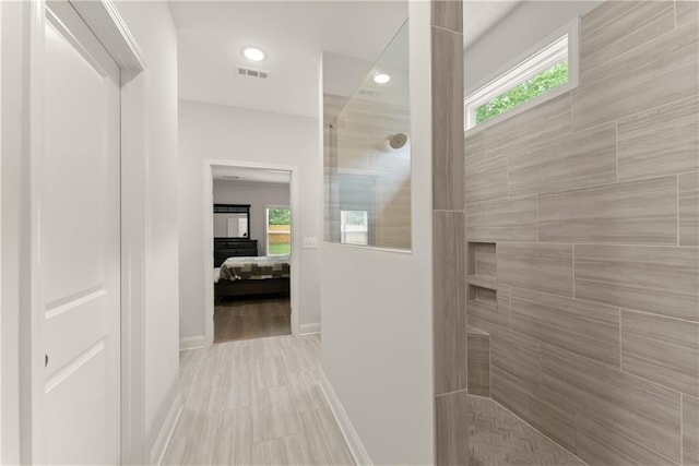 ensuite bathroom with a walk in shower, baseboards, and recessed lighting