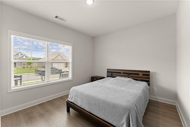 bedroom featuring wood finished floors, baseboards, and recessed lighting