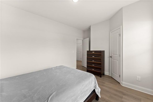 bedroom with light wood-type flooring and baseboards