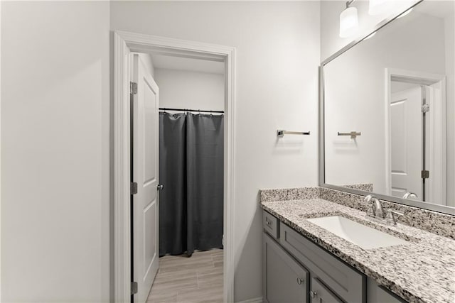 full bath featuring vanity and baseboards