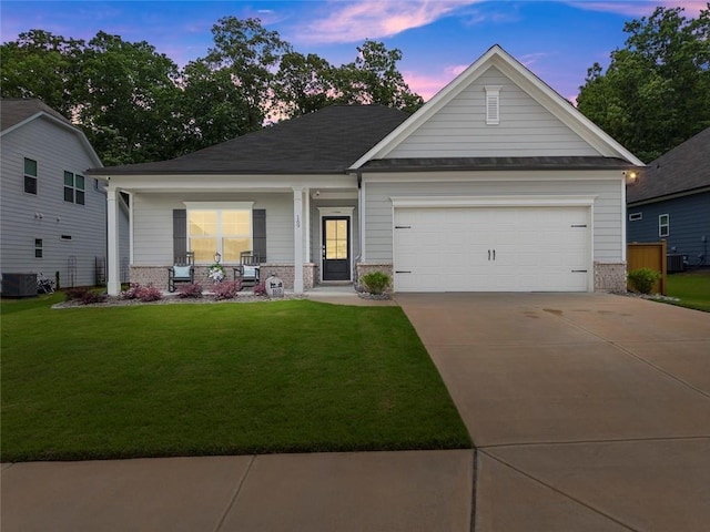 view of front facade with brick siding, a porch, a front lawn, driveway, and an attached garage