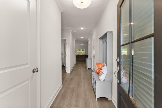corridor featuring crown molding, light wood-type flooring, baseboards, and recessed lighting