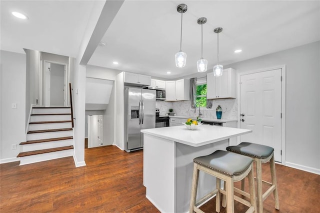1893 Burning Tree Dr, Decatur, GA 30032 - kitchen featuring light countertops, decorative backsplash, appliances with stainless steel finishes, white cabinets, and dark wood-style flooring