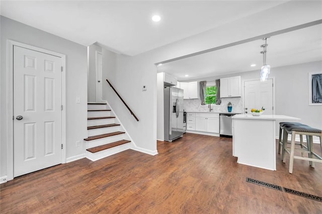 1893 Burning Tree Dr, Decatur, GA 30032 - kitchen with tasteful backsplash, dark wood finished floors, stainless steel appliances, white cabinets, and light countertops