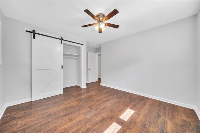 1893 Burning Tree Dr, Decatur, GA 30032 - unfurnished bedroom featuring ceiling fan, baseboards, a barn door, wood finished floors, and a closet