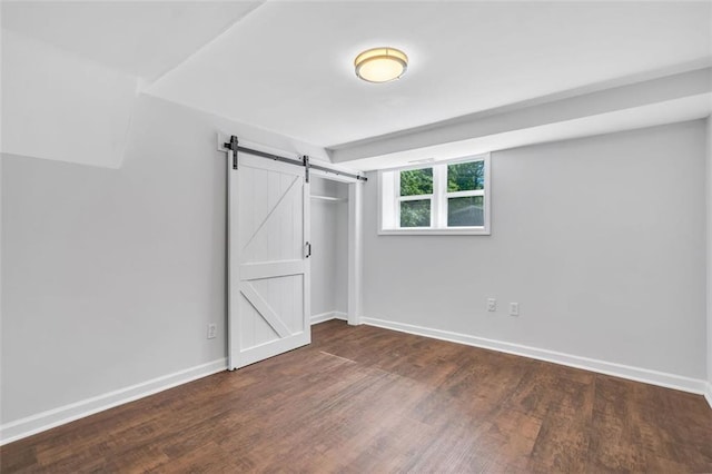 1893 Burning Tree Dr, Decatur, GA 30032 - unfurnished bedroom featuring a closet, a barn door, baseboards, and wood finished floors