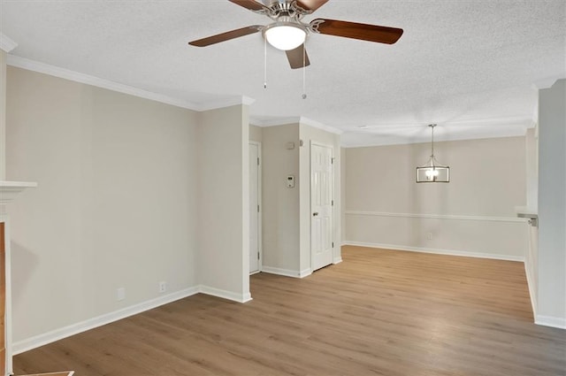 empty room with ornamental molding, a textured ceiling, wood-type flooring, and ceiling fan