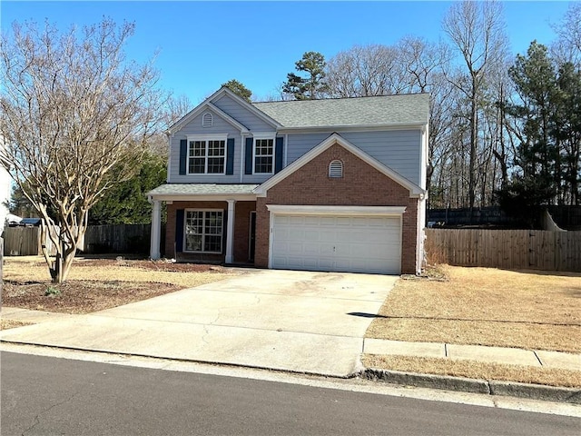 traditional-style home featuring an attached garage, fence, concrete driveway, and brick siding