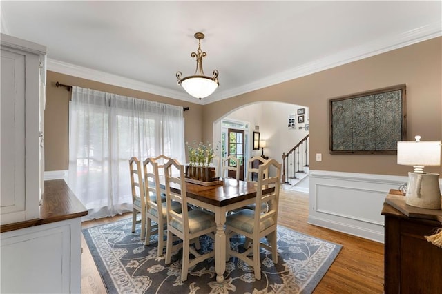 1254 Hadaway Garden Dr NW, Kennesaw, GA 30152 - dining space with arched walkways, crown molding, wood finished floors, wainscoting, and stairs