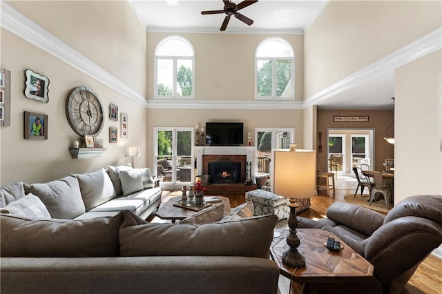 1254 Hadaway Garden Dr NW, Kennesaw, GA 30152 - living room featuring a towering ceiling, ceiling fan, wood finished floors, a brick fireplace, and ornamental molding