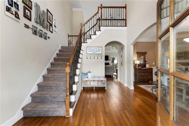 1254 Hadaway Garden Dr NW, Kennesaw, GA 30152 - entryway featuring arched walkways, wood finished floors, a towering ceiling, stairway, and crown molding