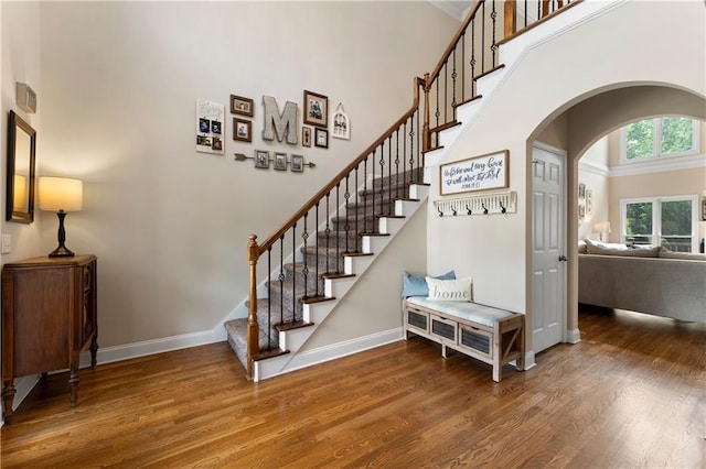 1254 Hadaway Garden Dr NW, Kennesaw, GA 30152 - staircase featuring a high ceiling, wood finished floors, and arched walkways