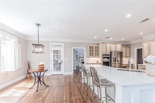 kitchen with visible vents, cream cabinetry, light countertops, baseboards, and appliances with stainless steel finishes