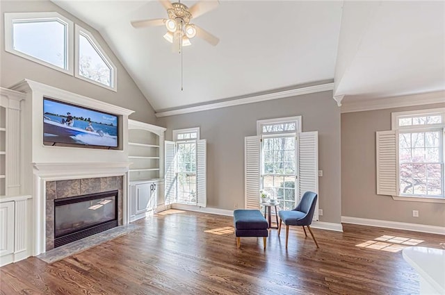 sitting room with a tile fireplace, ceiling fan, and plenty of natural light