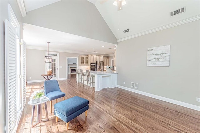living area with light wood-style flooring, a ceiling fan, and visible vents