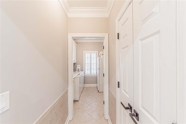 corridor with washing machine and dryer, crown molding, and light tile patterned flooring