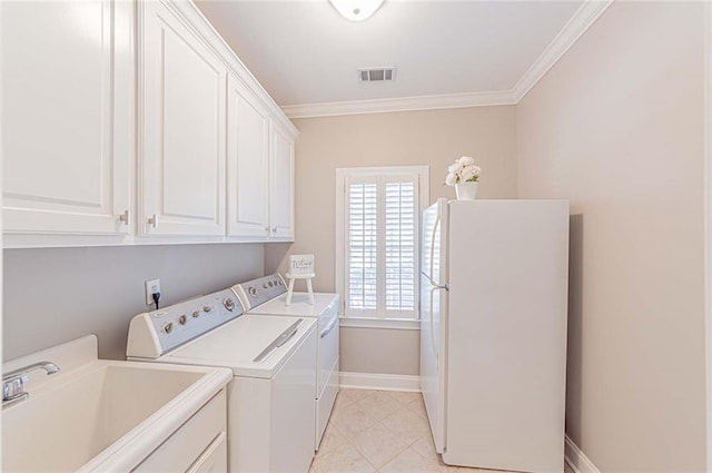 clothes washing area with a sink, cabinet space, ornamental molding, washing machine and dryer, and baseboards