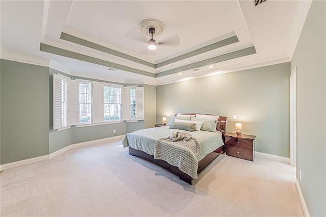 bedroom featuring ornamental molding, ceiling fan, carpet flooring, a tray ceiling, and baseboards