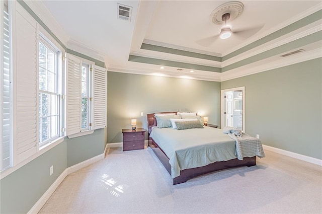 bedroom with light colored carpet, a raised ceiling, and visible vents
