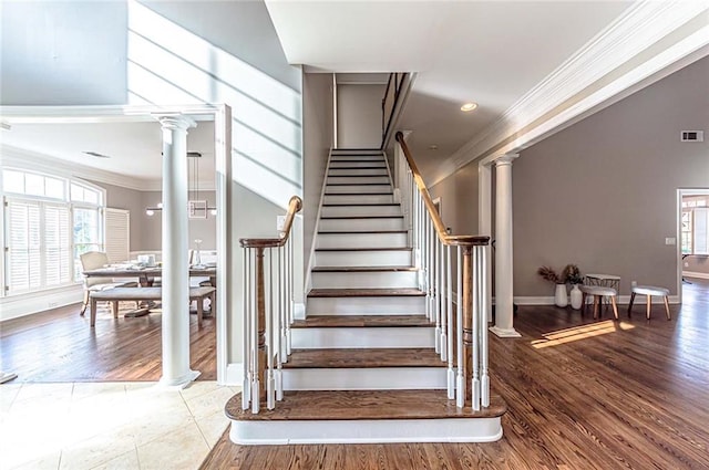 staircase featuring ornamental molding, baseboards, plenty of natural light, and decorative columns